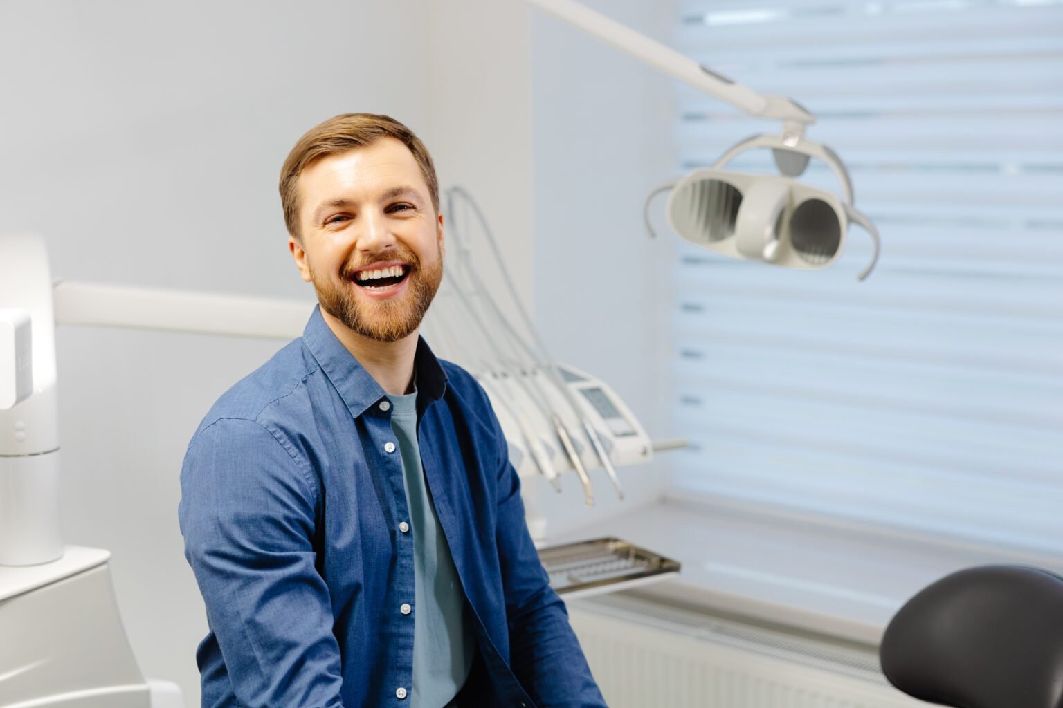 Mans smile is perfect Portrait of happy patient in dental chair after appointment