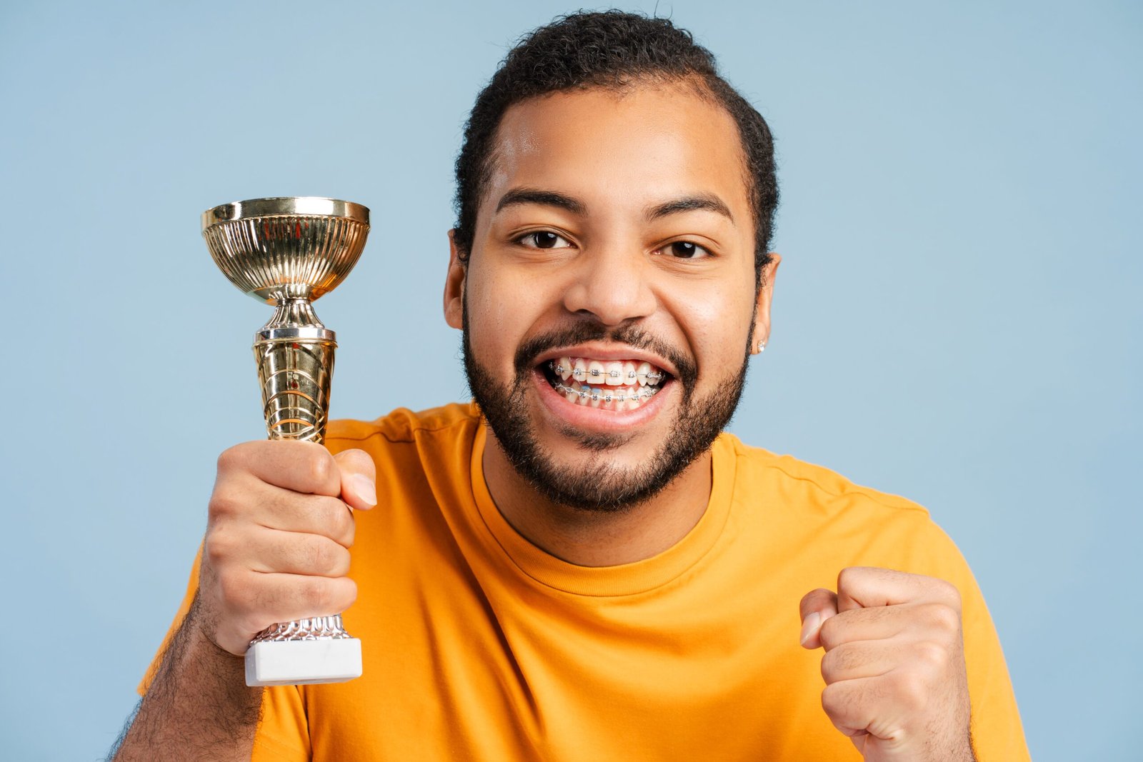 african american man with dental braces holding trophy his fist clenched victory gesture 695242 9062 scaled 1 Patients important information